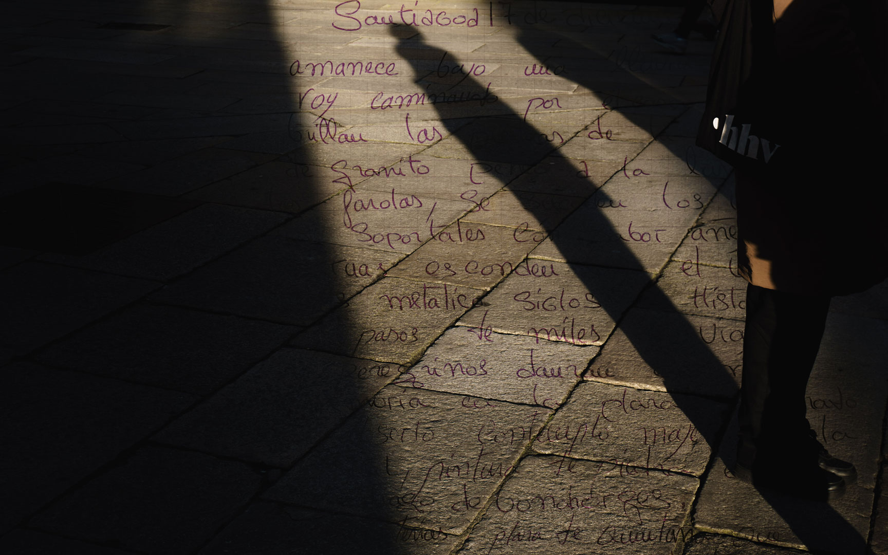 Composición fotográfica de una carta escrita a mano sobre el plano con sombra de persona.