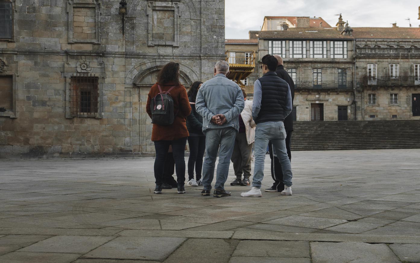 Un corrillo de personas conversan en la plaza de A Quintana dos Mortos en Santiago de Compostela