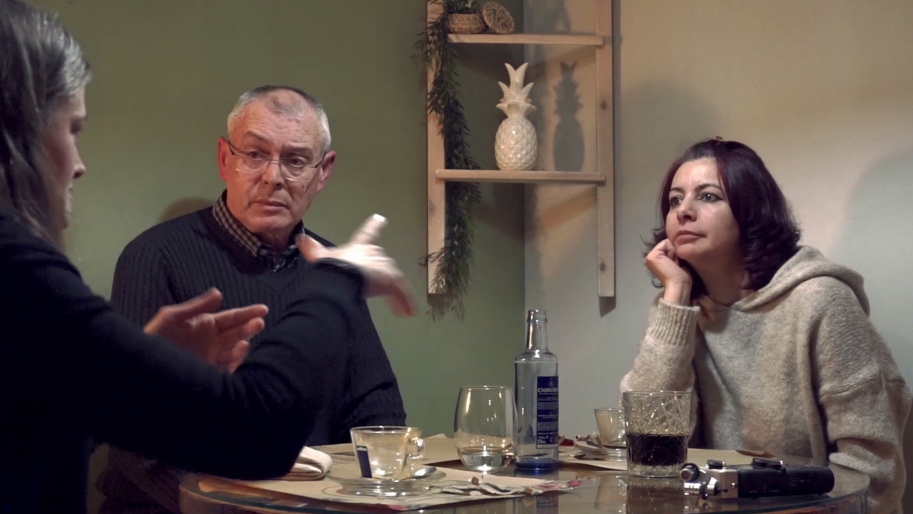 3 personas sentadas en un restaurante conversando en lengua de signos